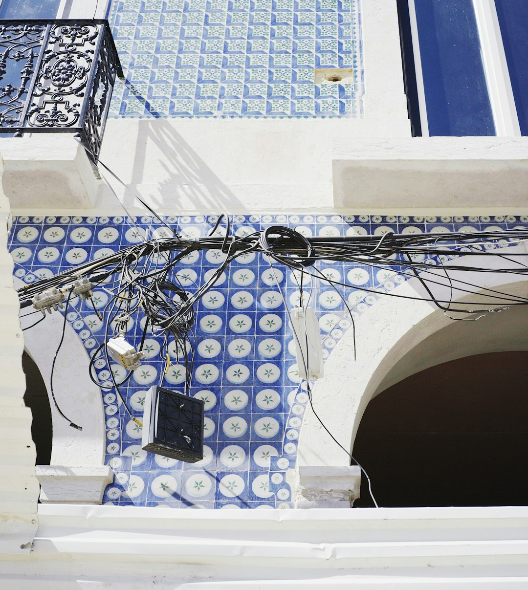 a-building-facade-adorned-with-blue-tiles-and-cables-eglb-le44cw