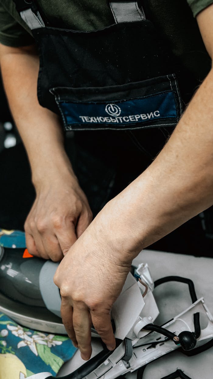 Close-up of a technician fixing a home appliance, emphasizing skill and craftsmanship.
